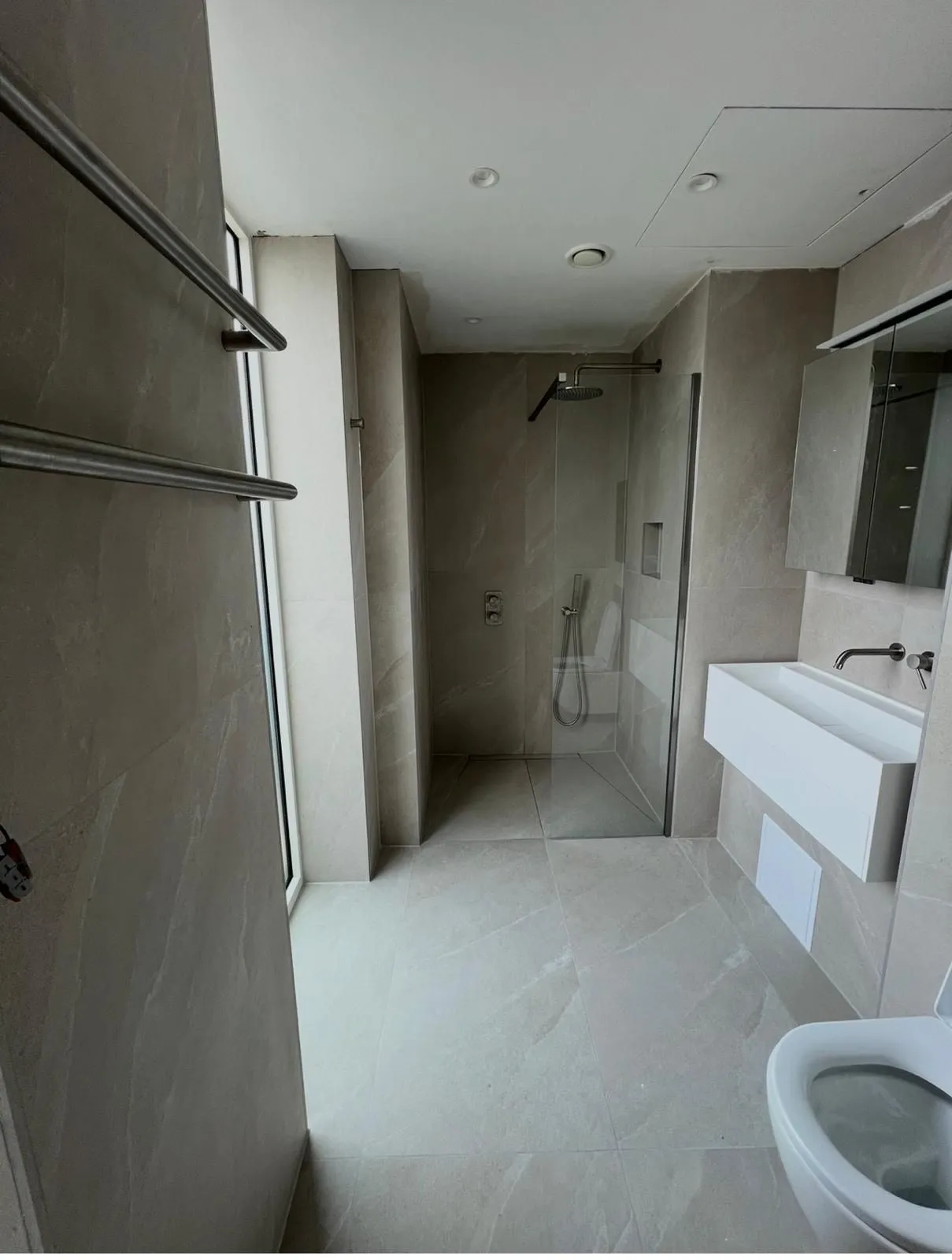 Narrow shower room tiled floor to ceiling in light grey porcelain