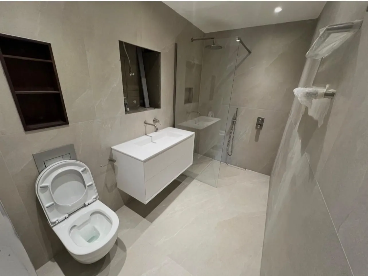 Grey porcelain bathroom with a walk-in shower, wall-hung toilet and floating basin