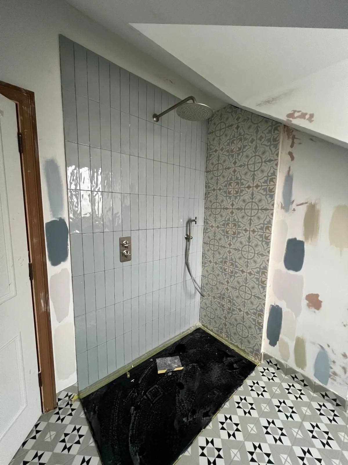 Shower with blue patterned floor tiles and light metro walls