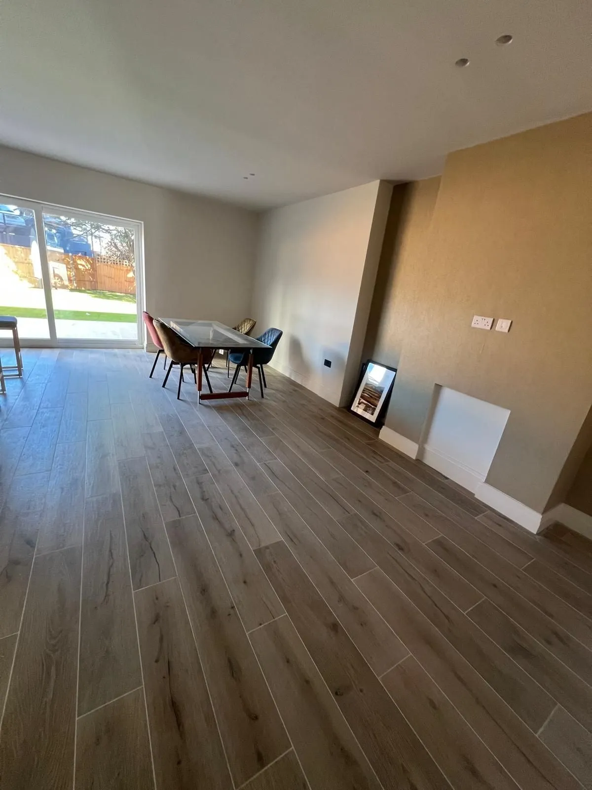 Living room with wood-effect floor laid in a straight run to the garden doors
