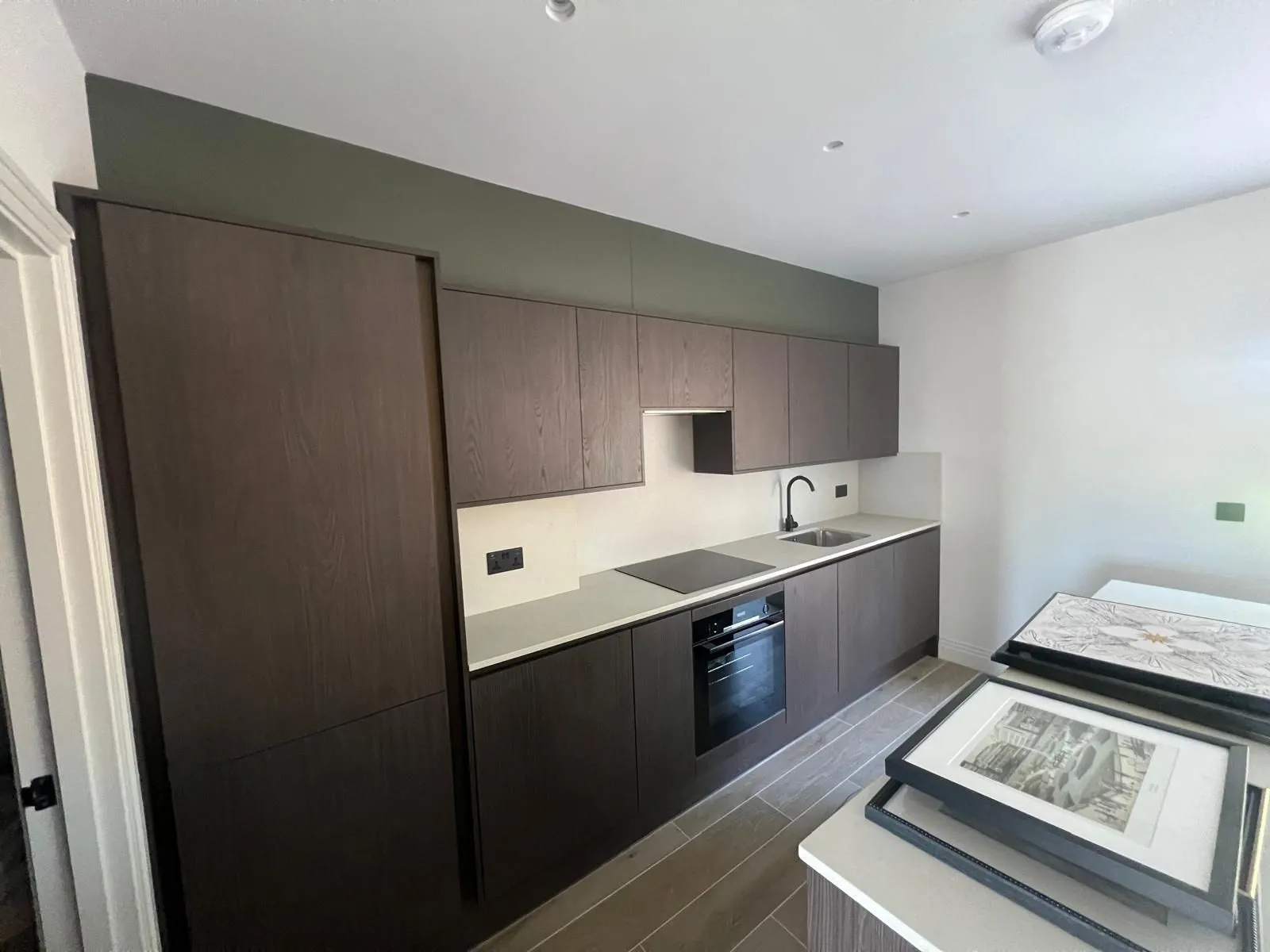Galley kitchen with dark wood-effect units and a light worktop