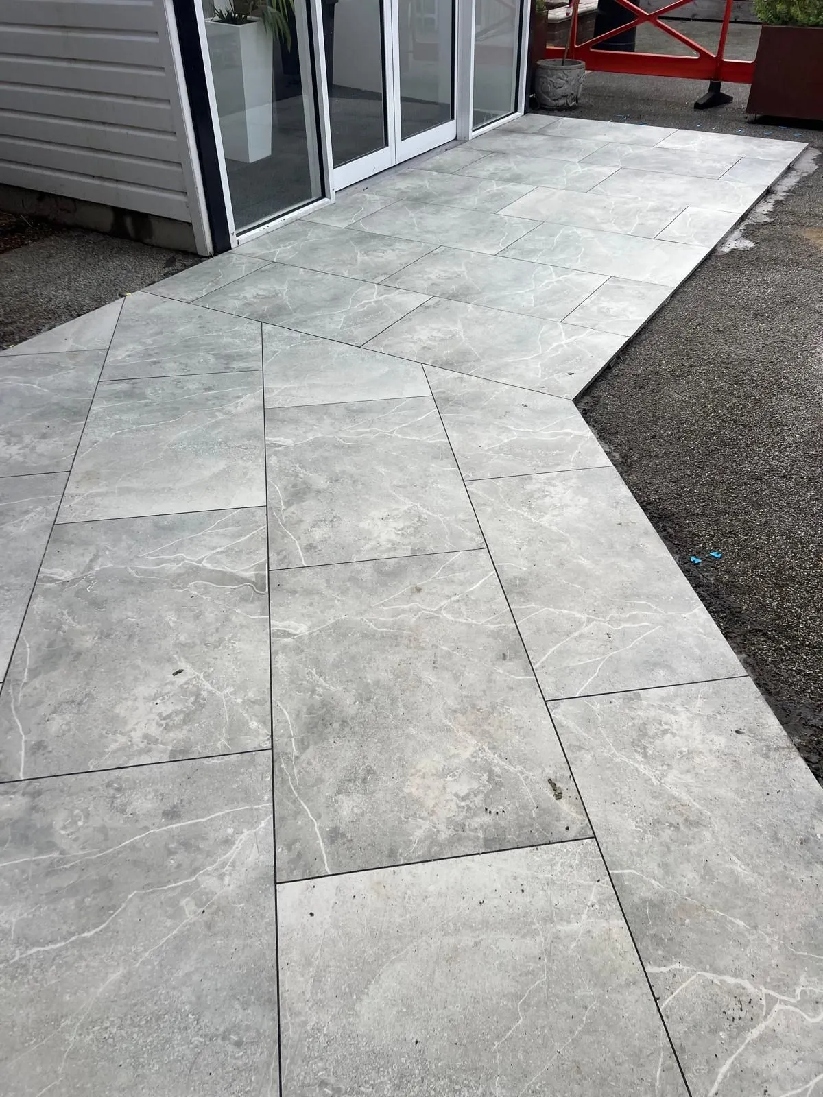 Outdoor porcelain path turning at an angle beside a building