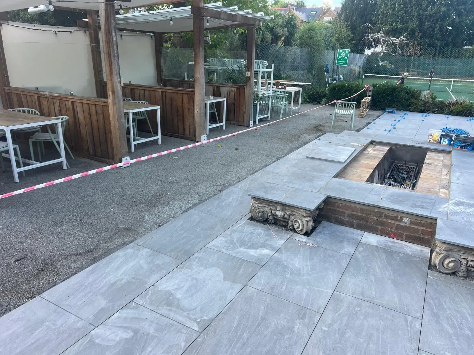 Grey outdoor porcelain terrace around a raised brick fire pit