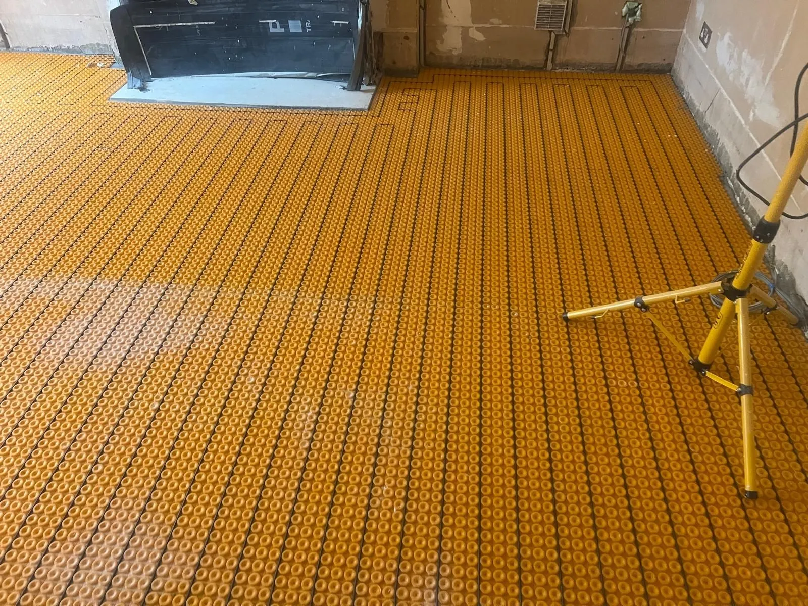Underfloor heating mat laid across a bathroom floor before tiling