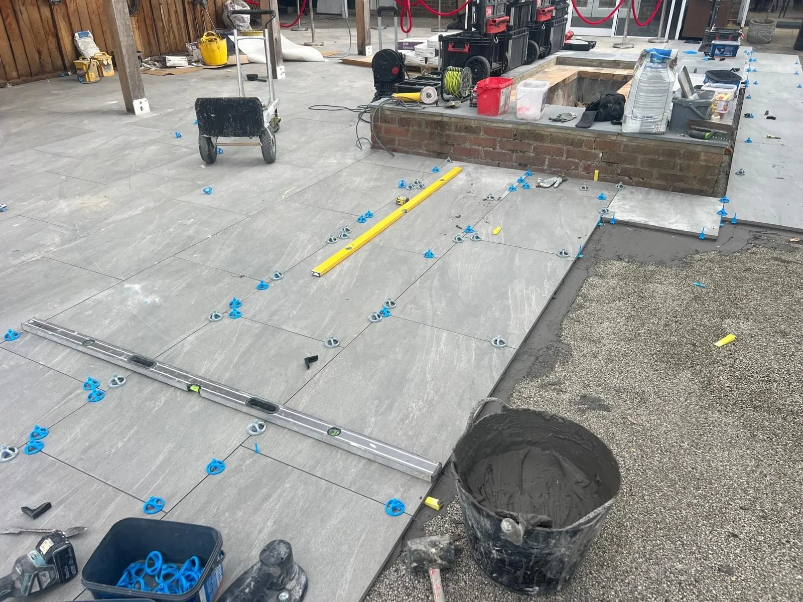 Outdoor porcelain being laid with levelling clips and a long spirit level